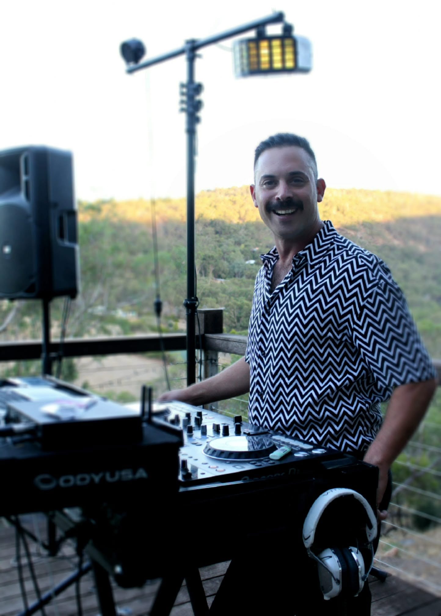 Eran at his DJ setup with mountain backdrop